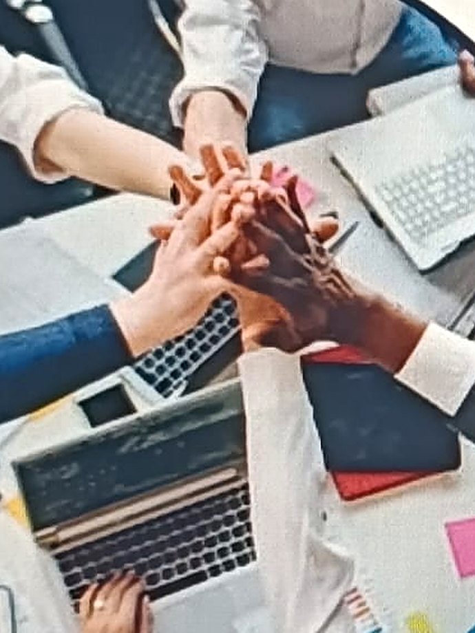 Riunione di lavoro: mani unite sopra il tavolo